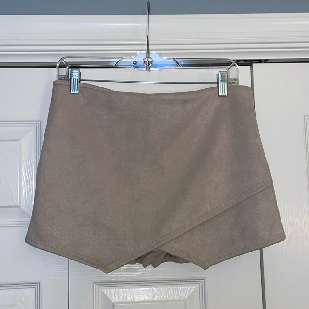 Women’s nude shorts with crossover fabric in the front. Zipper close.